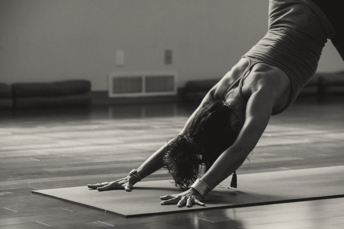A woman in downward-facing dog in a studio