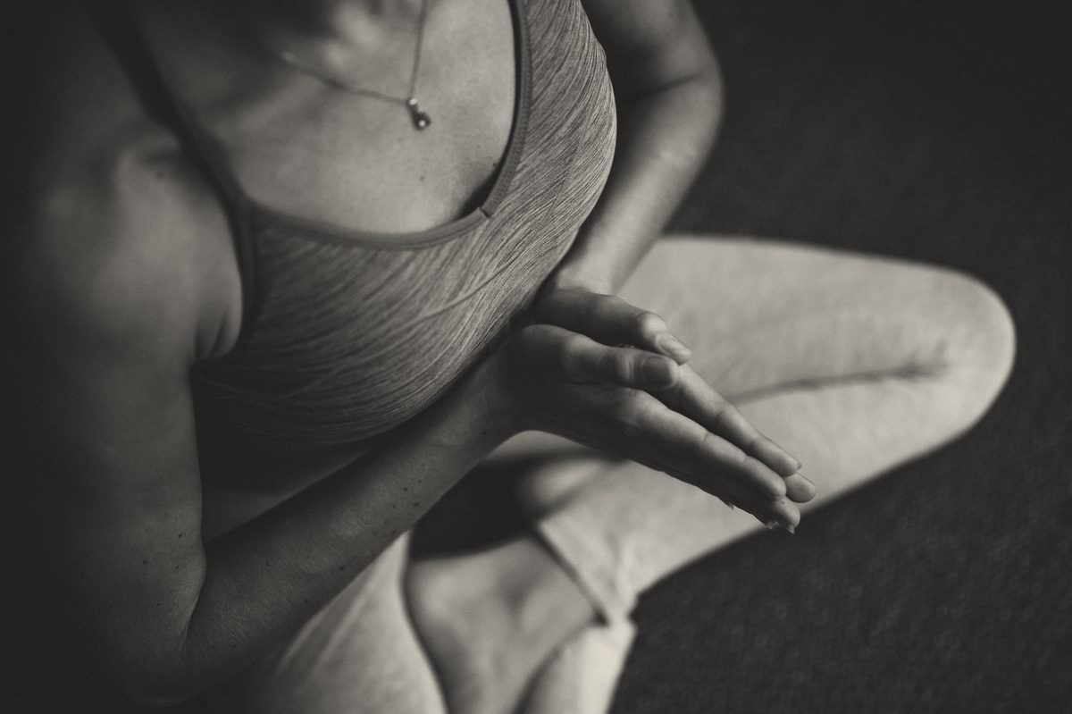 Hands resting on a knee in a seated stretch